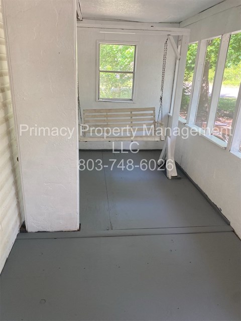 A room with a window and a door, managed by Primacy Property Management LLC.