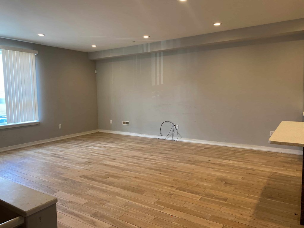 a living room with a hard wood floor and gray walls