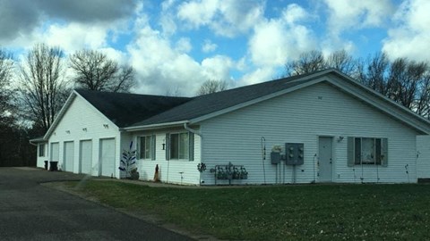 a white church with a black roof and a lawn