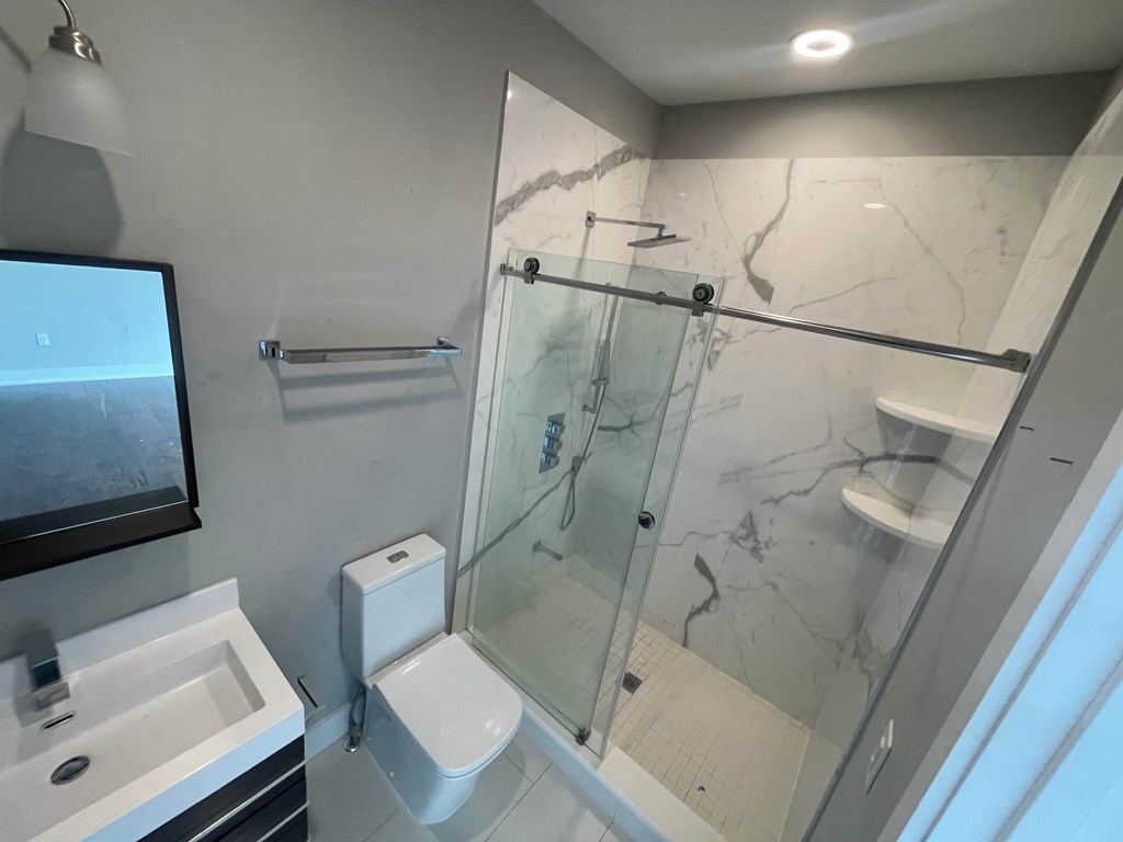 a bathroom with a shower and a sink and a toilet