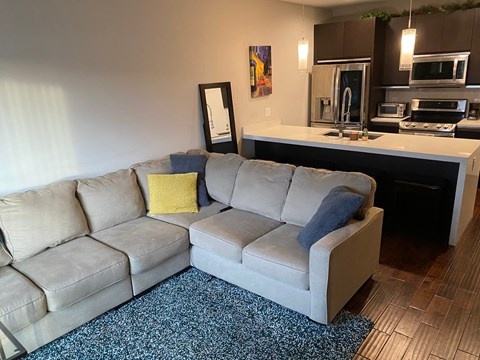 a living room with a couch in front of a kitchen