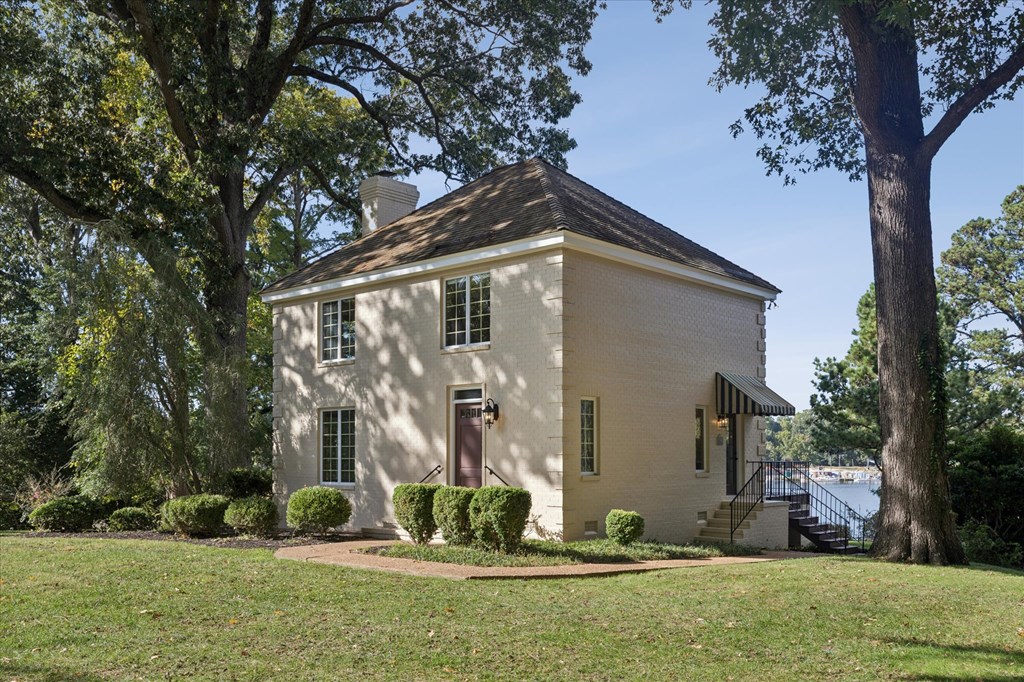 A small white house with a brown door and a brown roof.