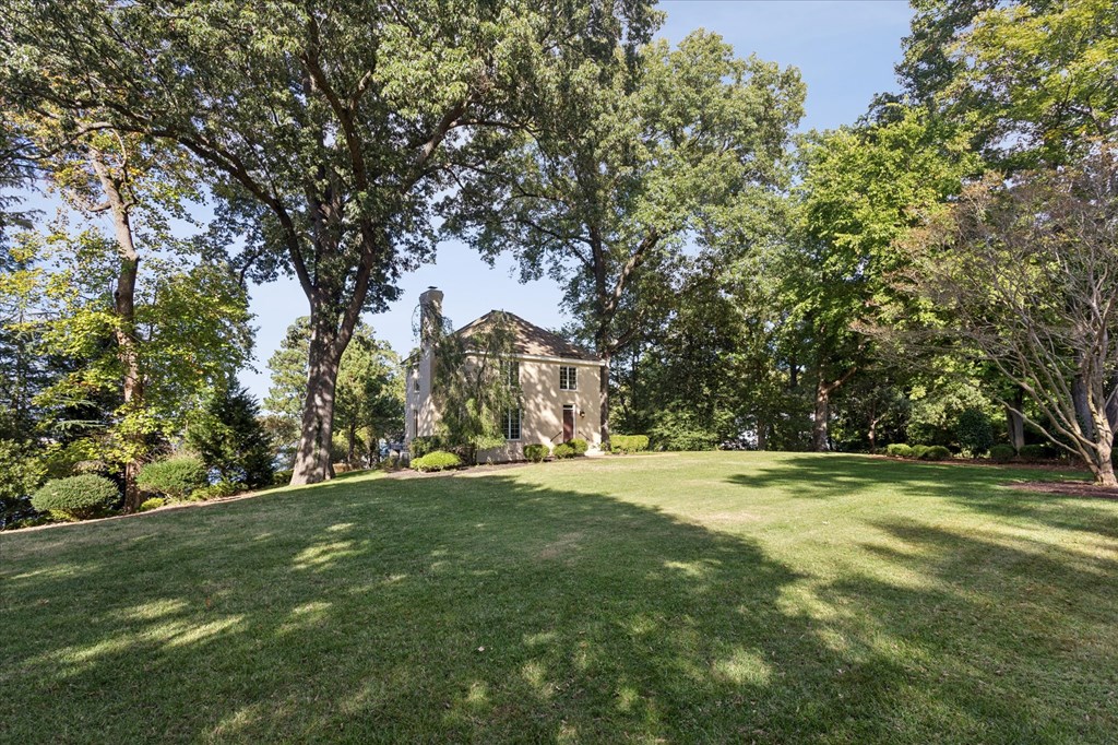 A large, old building sits in the middle of a lush green field.
