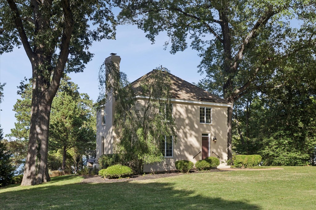 A large house with a red door is surrounded by trees.