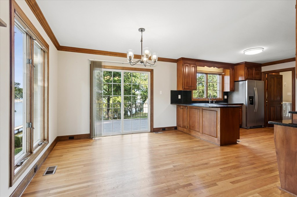 A kitchen with wooden floors and a chandelier.