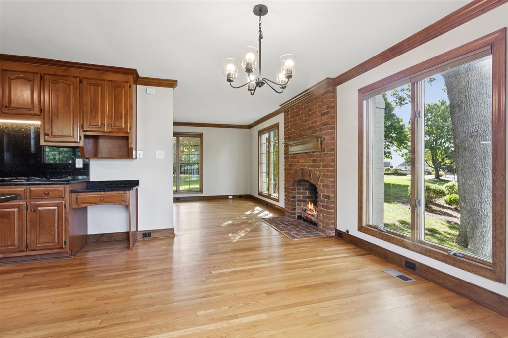 A large open living room with a fireplace and a chandelier.