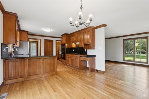 A kitchen with wooden cabinets and a black countertop.