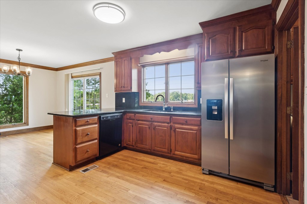 A kitchen with wooden cabinets and a stainless steel refrigerator.