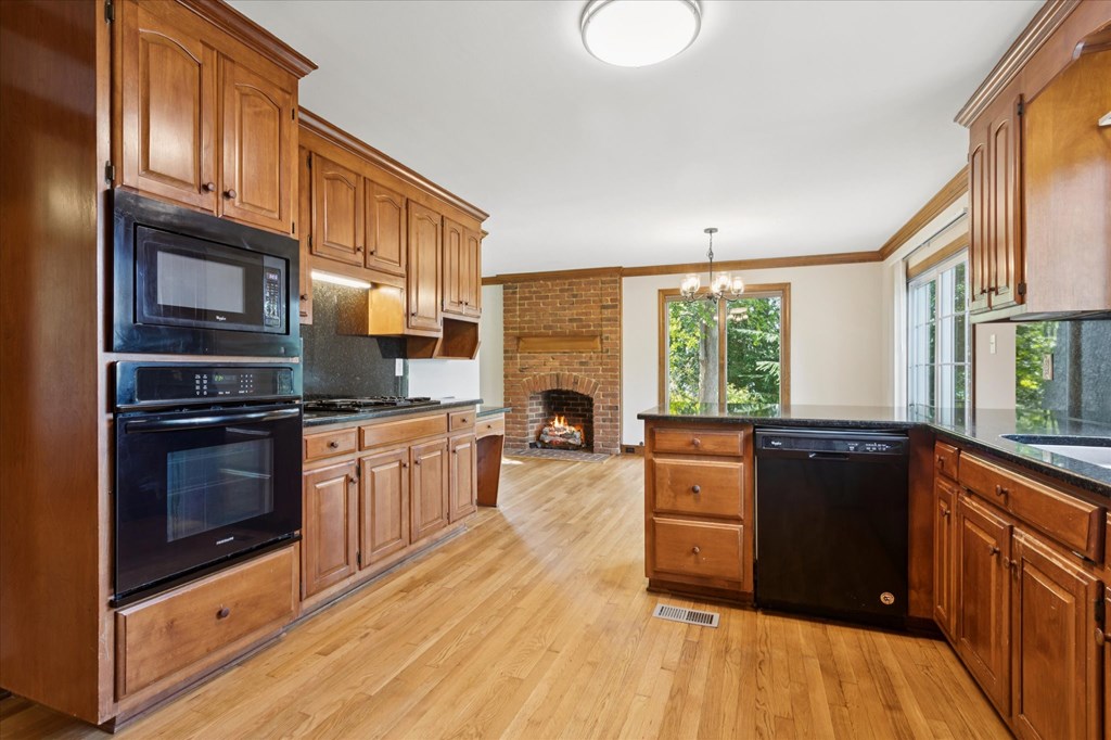A kitchen with wooden cabinets and a brick fireplace.