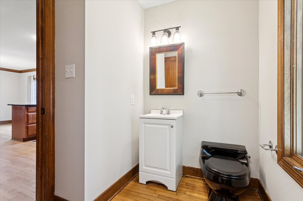 A white cabinet with a sink and a toilet in a bathroom.