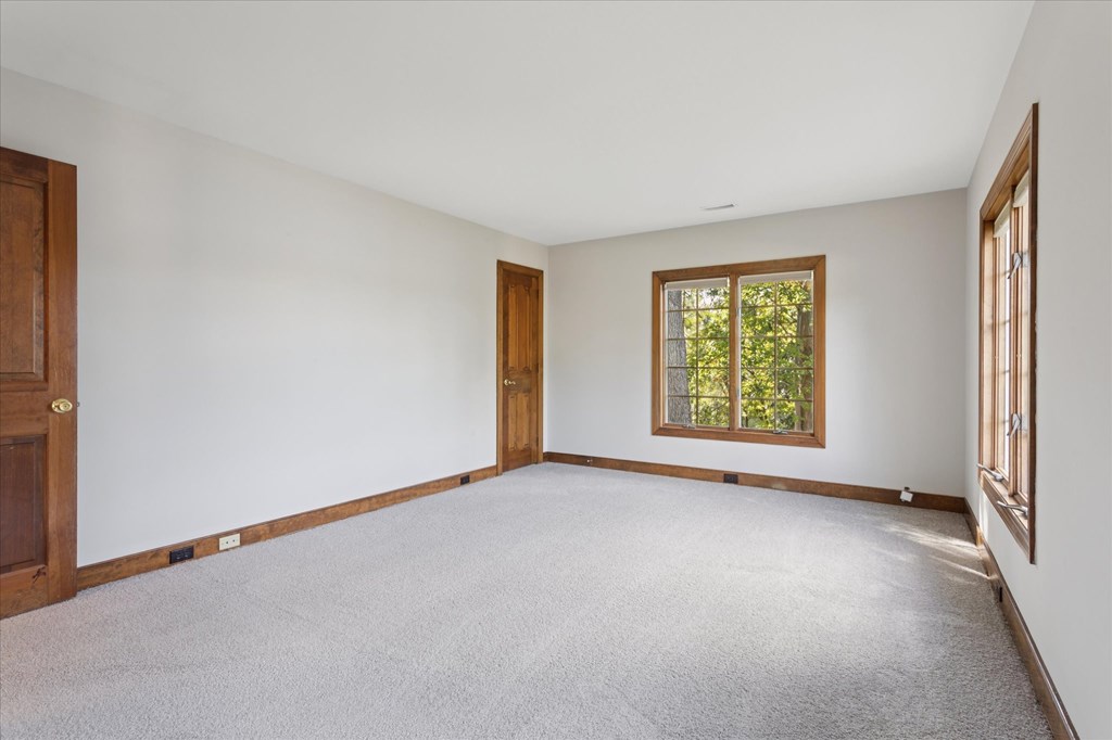 A room with a carpeted floor and a window.