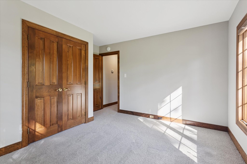 A room with a wooden door and a carpeted floor.