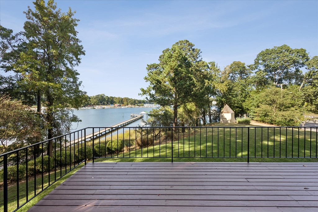 A wooden walkway leads to a body of water with trees on either side.