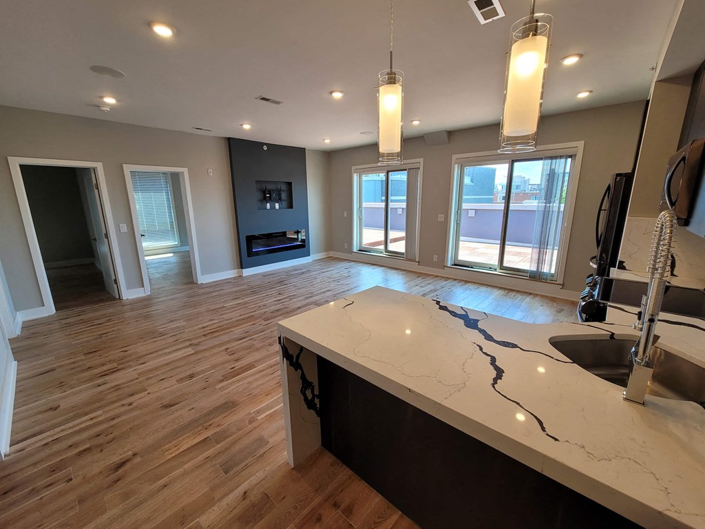 a kitchen and an empty living room with a sink
