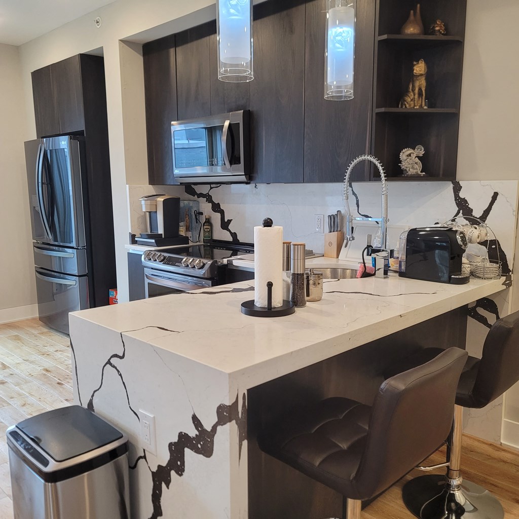 a kitchen with a marble counter top and a refrigerator and a microwave