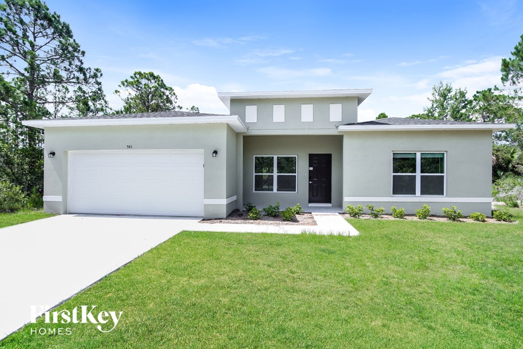a white house with a lawn in front of it