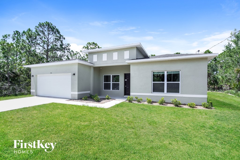 a white house with a lawn in front of it