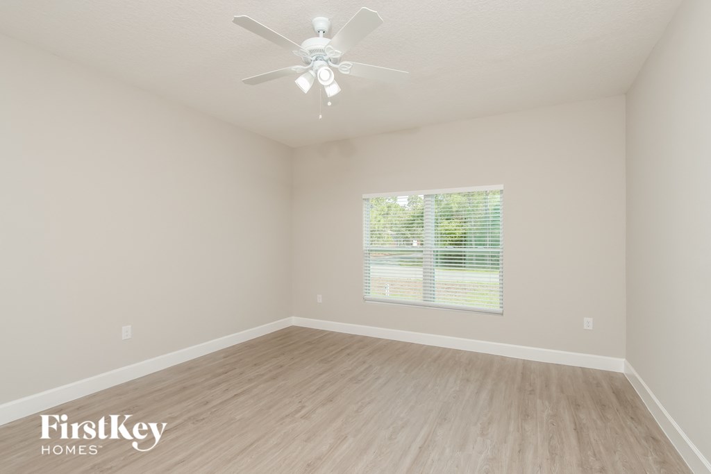a spacious living room with hardwood floors and a ceiling fan