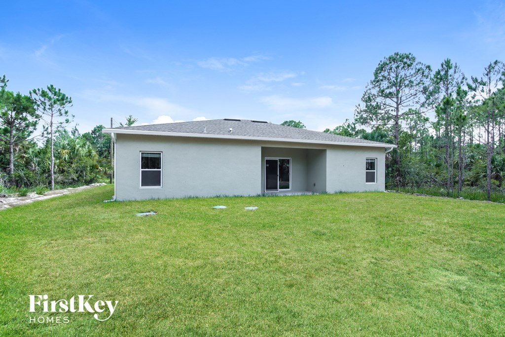 a small white house sitting on a grass covered field