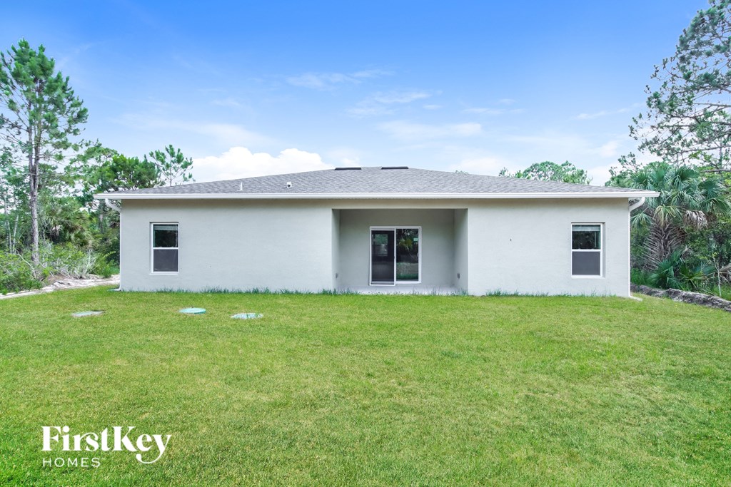 a small white house with a lawn in front of it