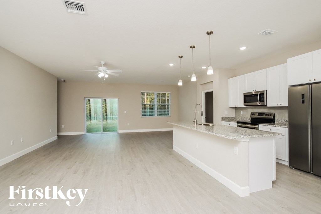 A spacious kitchen with a bar area and a refrigerator.