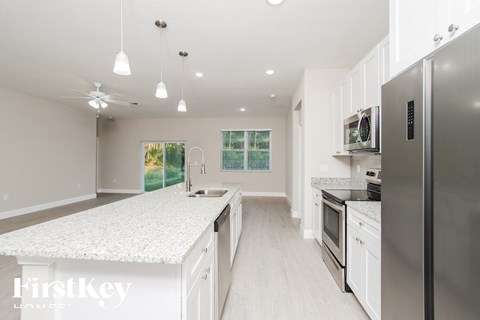 A modern kitchen with white cabinets and a stainless steel refrigerator.