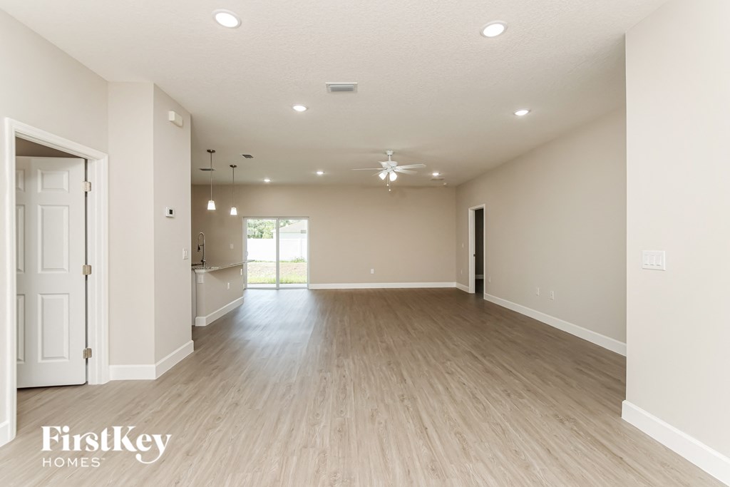 A spacious room with wooden flooring and a ceiling fan.