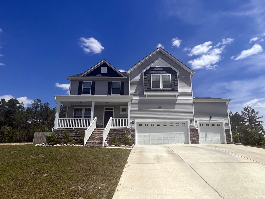 A two-story house with a garage and a covered porch.