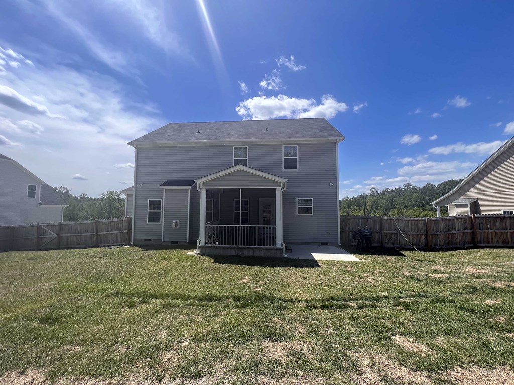 A house with a grey roof and a white fence.