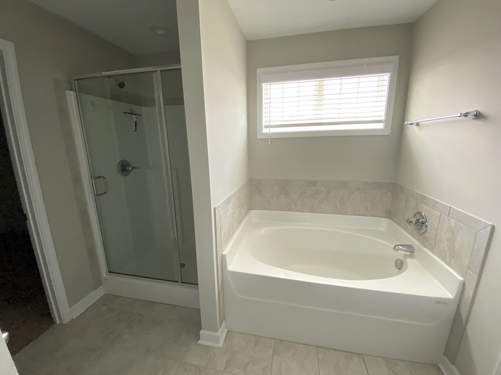 A white bathroom with a tub and shower.