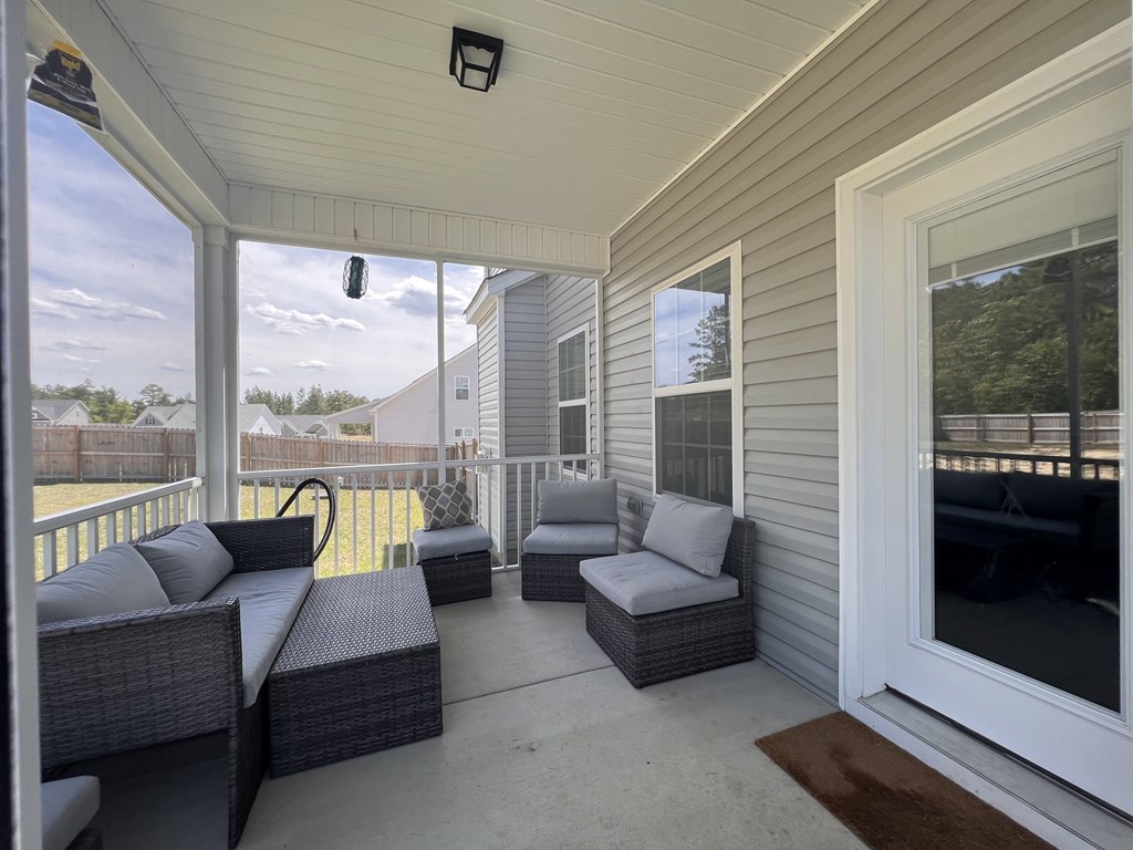 A patio with grey furniture and a white door.
