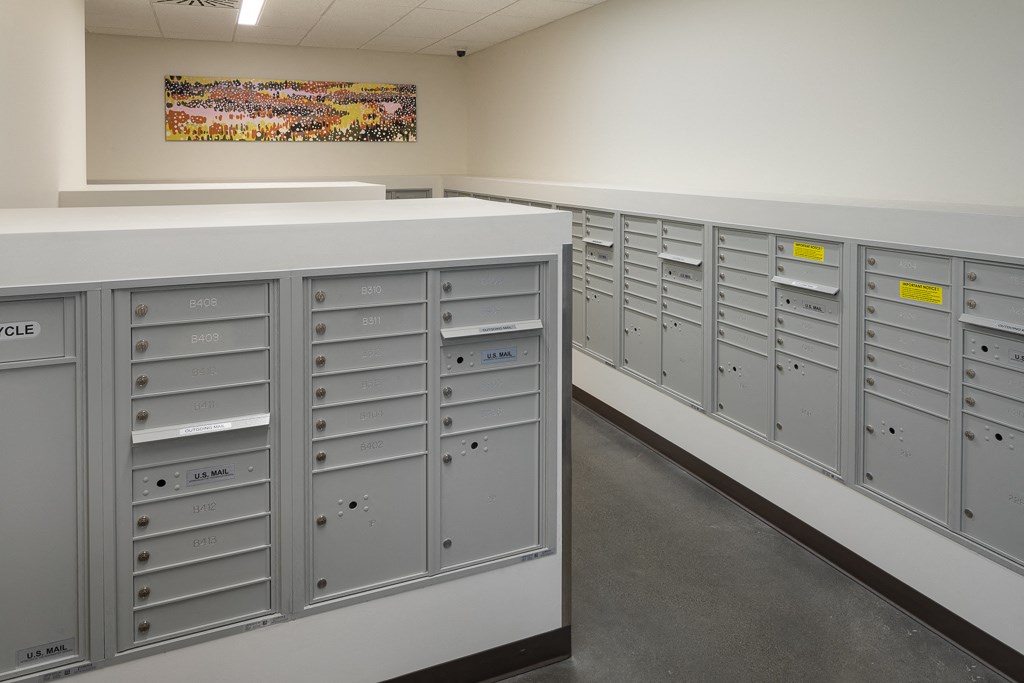 a row of lockers in a building with a painting on the wall