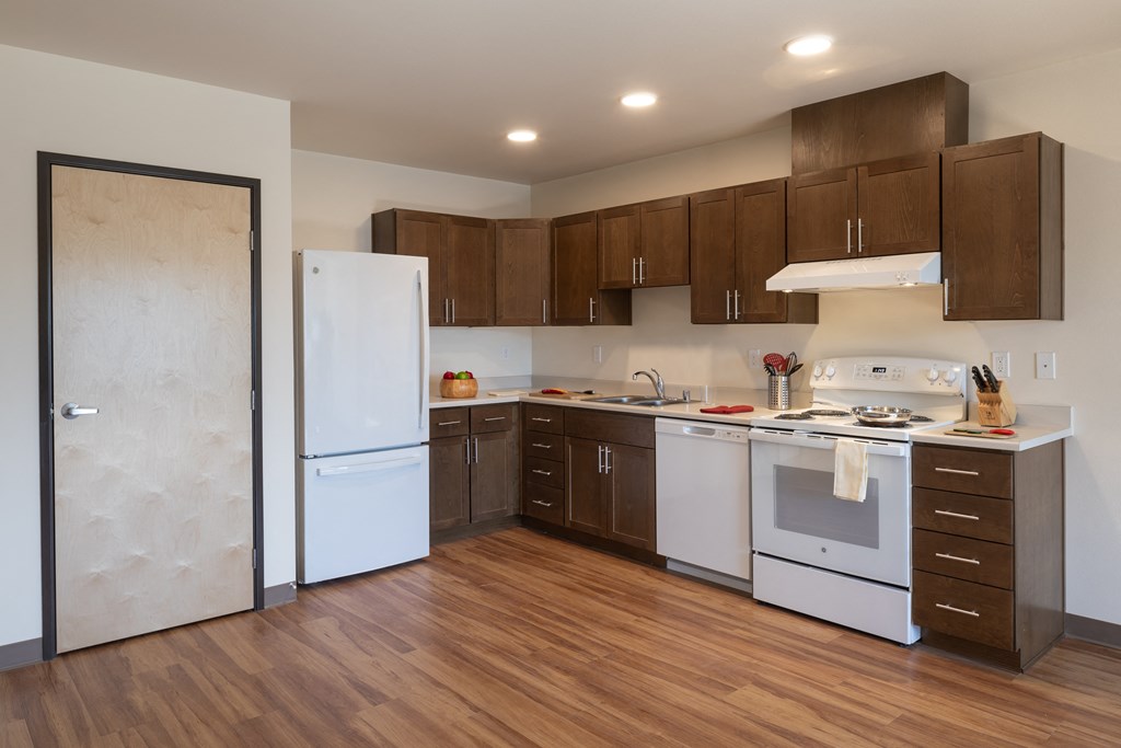 a kitchen with white appliances and wooden cabinets