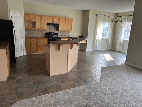 an empty kitchen with an island in the middle of it