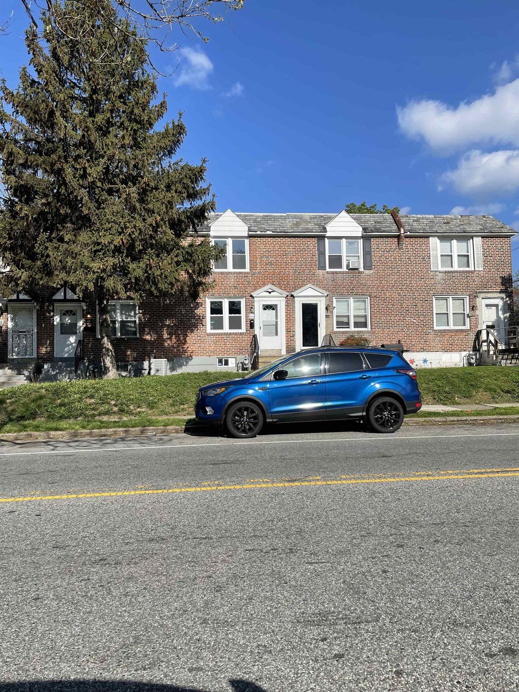 a blue car parked in front of a house