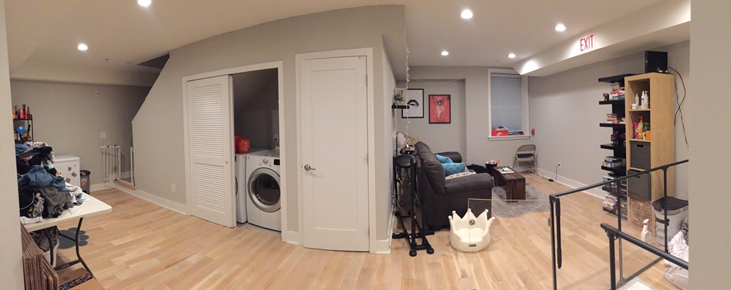 a living room with a washer and dryer in it and a laundry room