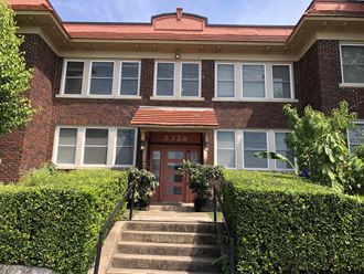 a red brick house with a red door and stairs in front of it
