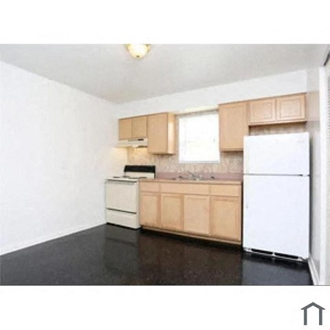 A kitchen with a white fridge, white dishwasher, and brown cabinets.