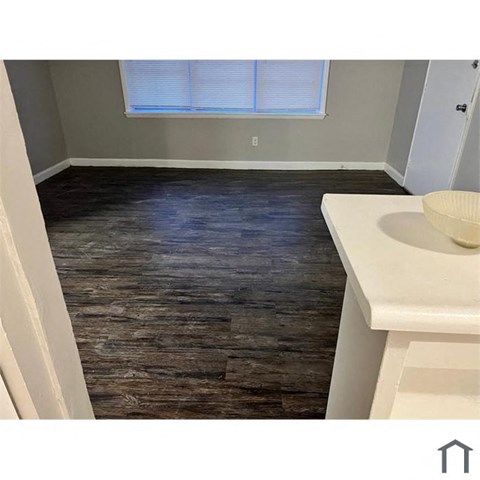 A bathroom with a wooden floor and a white sink.