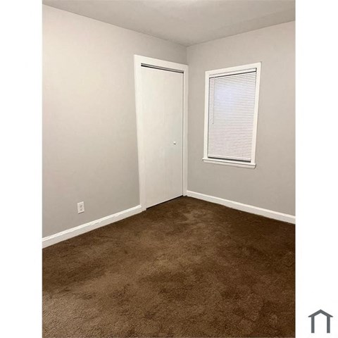 A room with a brown carpet and a white door.
