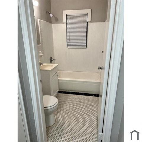A white bathroom with a toilet, sink, and bathtub.