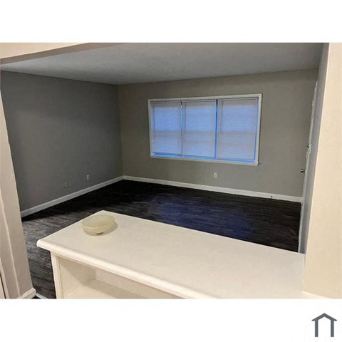 A room with a window and a white table.