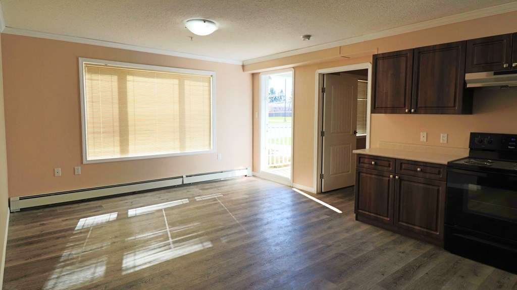 an empty kitchen and living room with wood floors