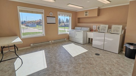 A laundry room with washers and dryers and a view of the outside.
