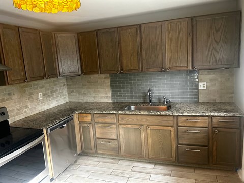 A kitchen with wooden cabinets and a granite countertop.
