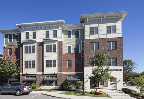 an apartment building with a car parked in front of it