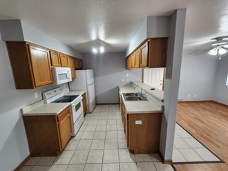 an empty kitchen with wooden cabinets and white appliances