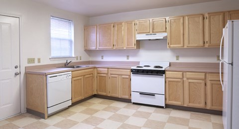 A kitchen with wooden cabinets and a checkered floor.