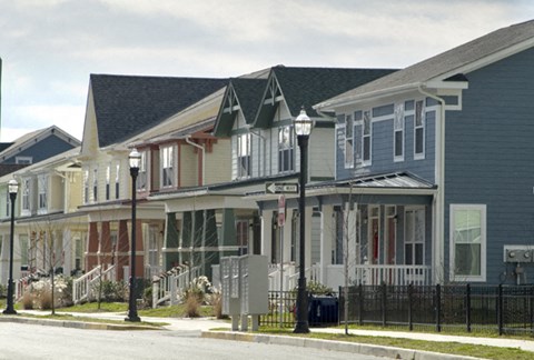 A row of houses with a black fence in front.