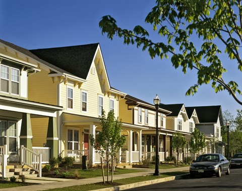 A row of houses with a car parked on the street.